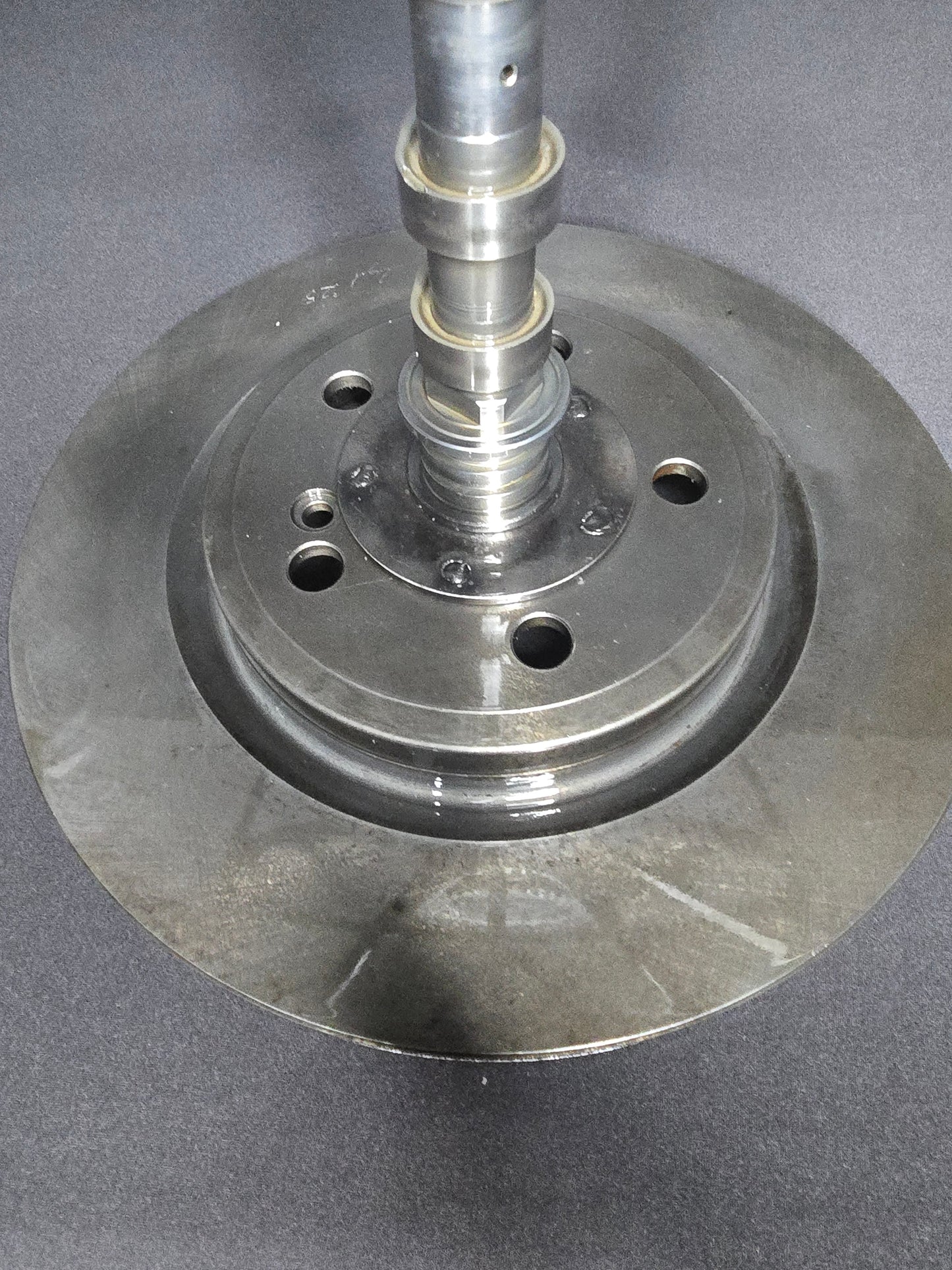 Metal turntable base with central shaft and bolt holes
