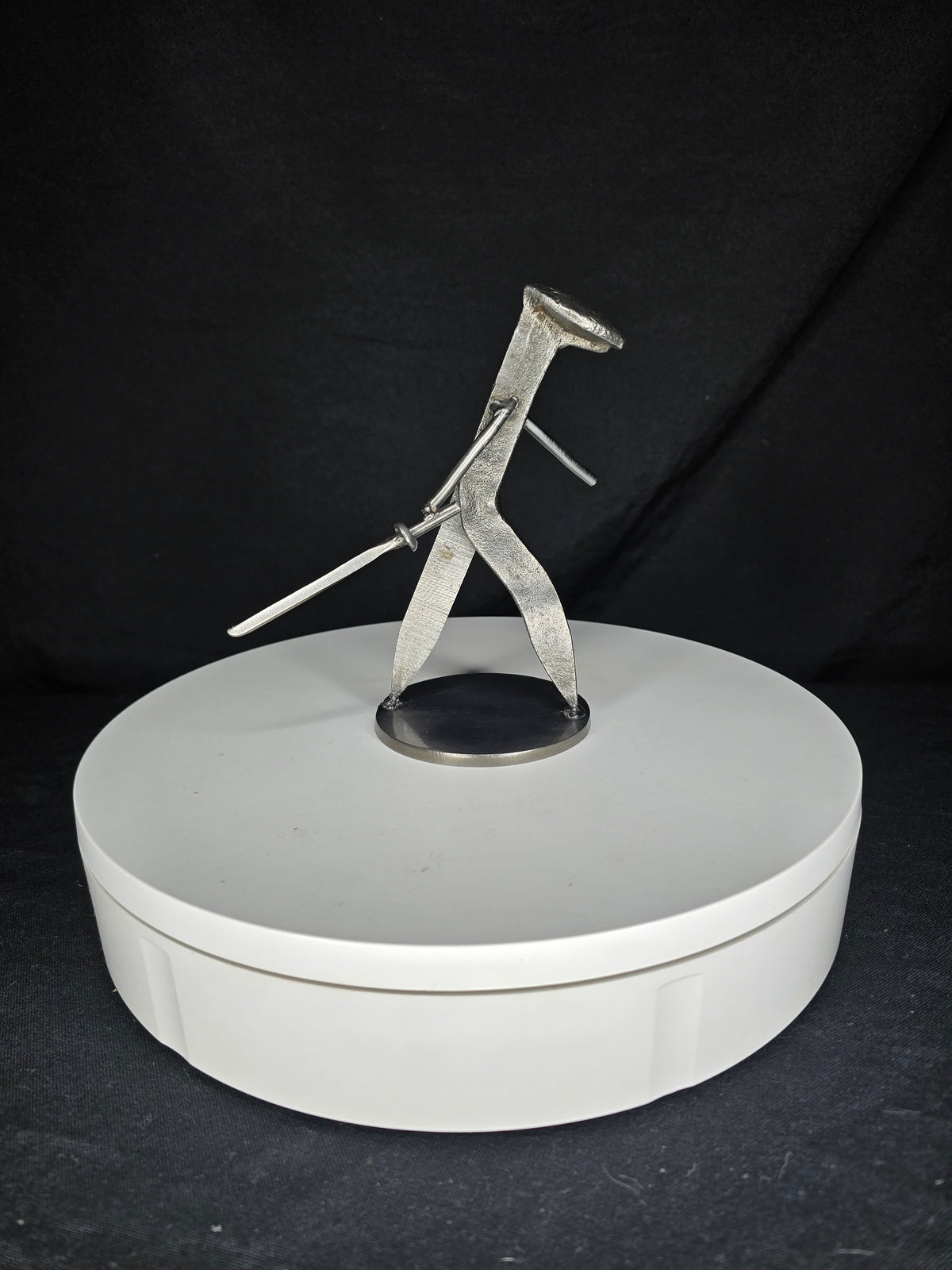 The Martial Artist reclaimed railroad spike sculpture holding a steel sword in a martial arts stance.