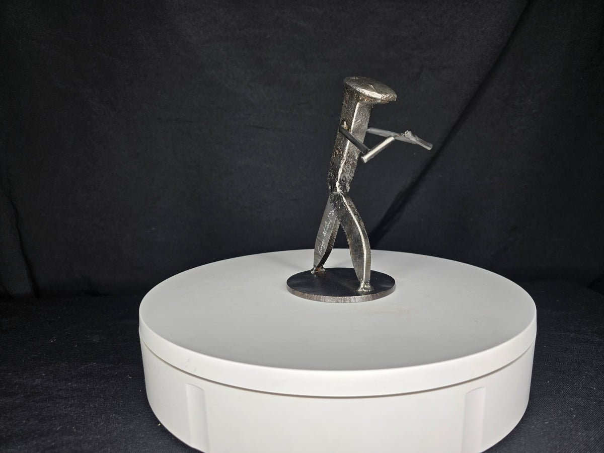 The Martial Artist reclaimed railroad spike sculpture holding nunchaku in a martial arts stance.