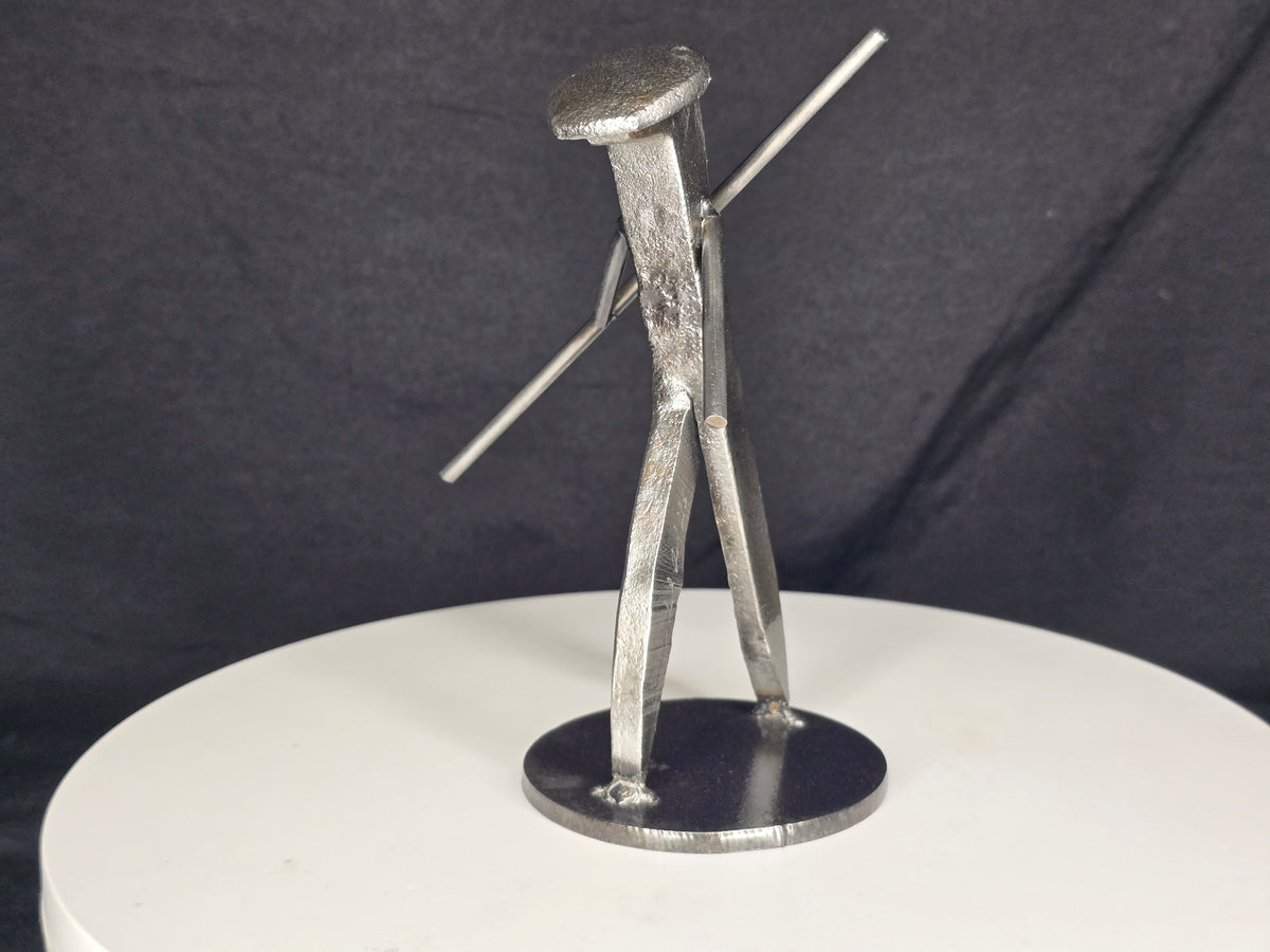 The Martial Artist handcrafted railroad spike sculpture holding a Bo staff in a forward-moving martial arts stance.