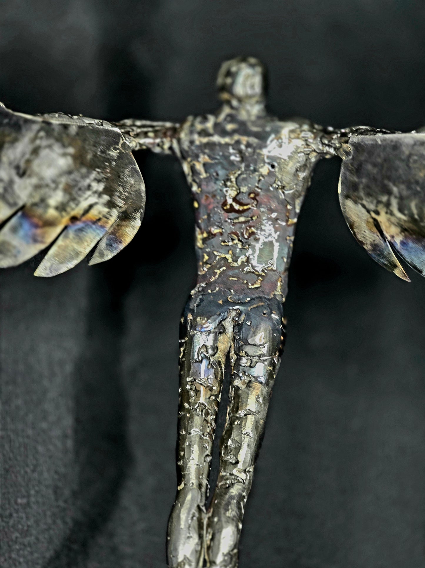 Ikarus: The Day After sculpture by Enrique Del Angel, forged steel figure with heat-colored wings.