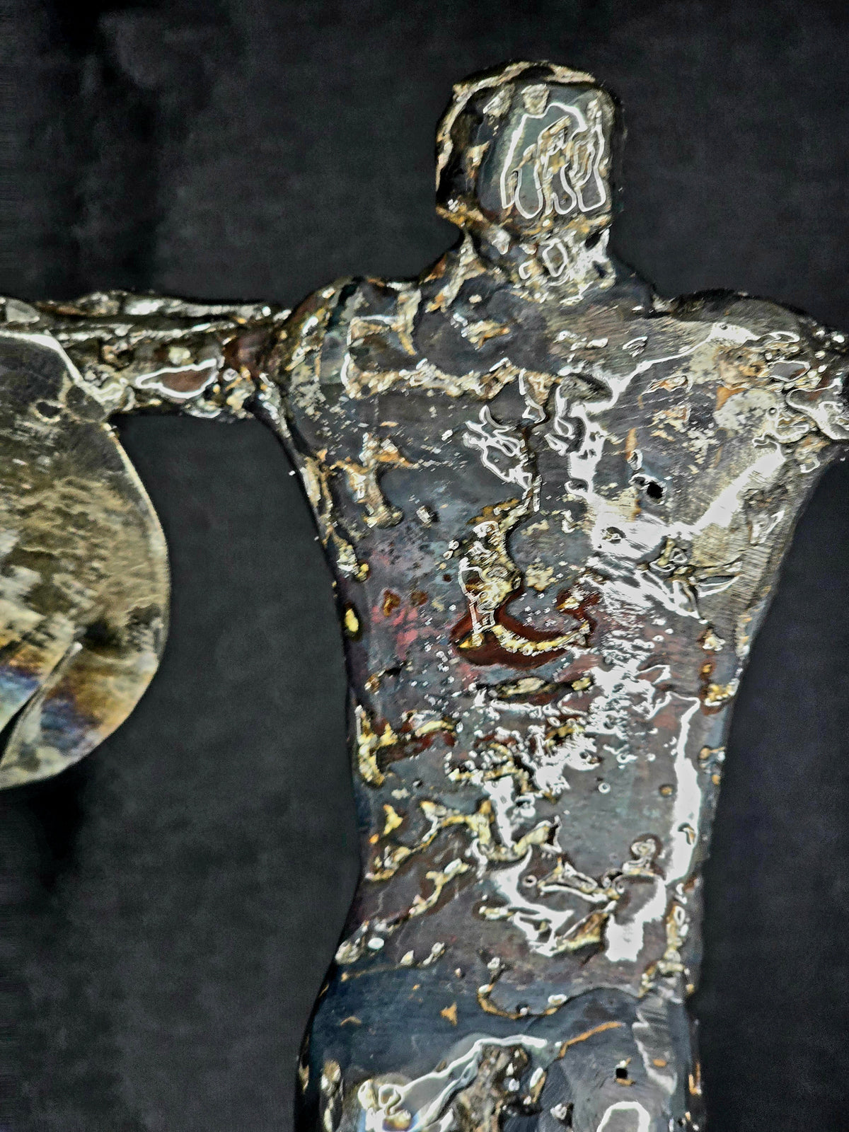Ikarus: The Day After sculpture by Enrique Del Angel. Torso of a figure made of reclaimed steel with heat-colored accents.
