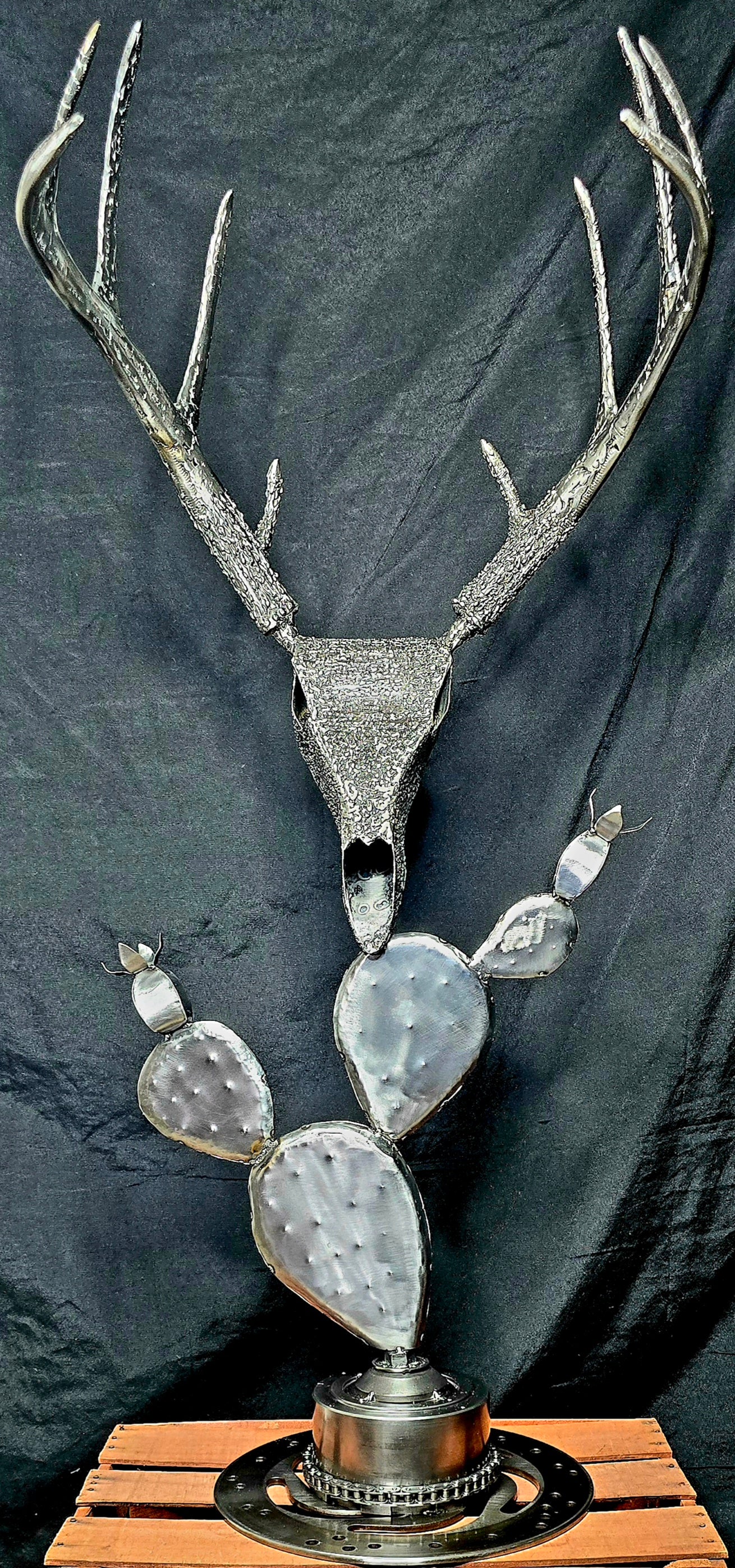 Handcrafted metal sculpture symbolizing the persistence of life through time, forged from reclaimed steel and natural elements by Enrique Del Angel.
