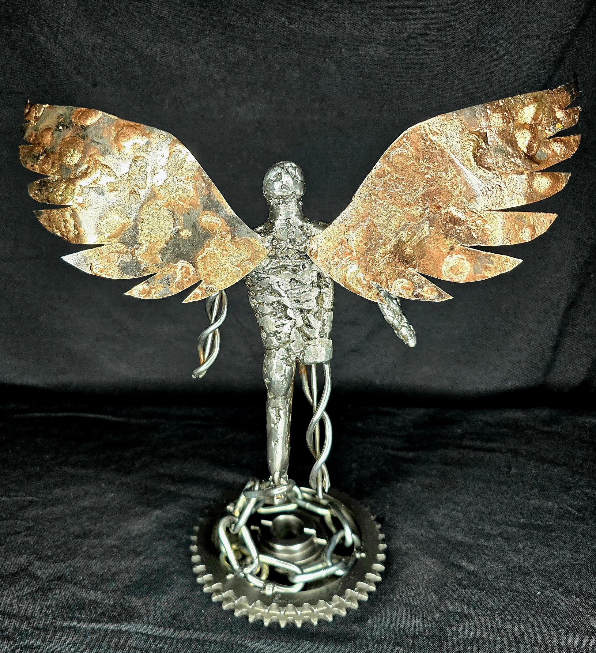 Gold-and-silver metal angel ornament front view with wide wings and gear base