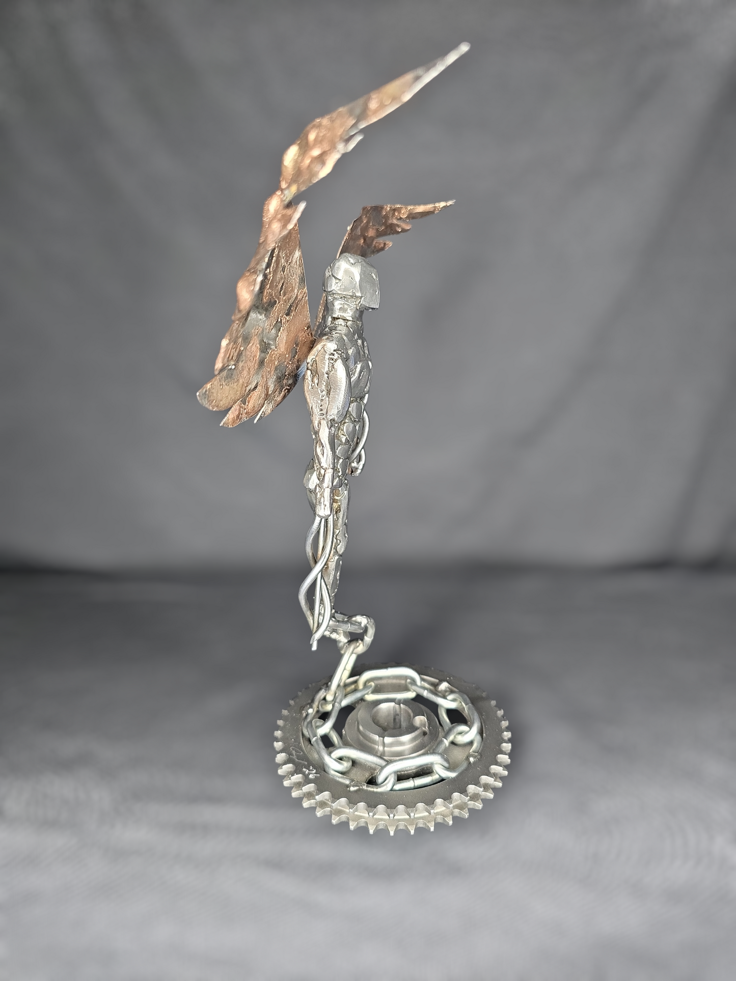 Metal angel ornament with gold-toned wings and silver chain, round gear base