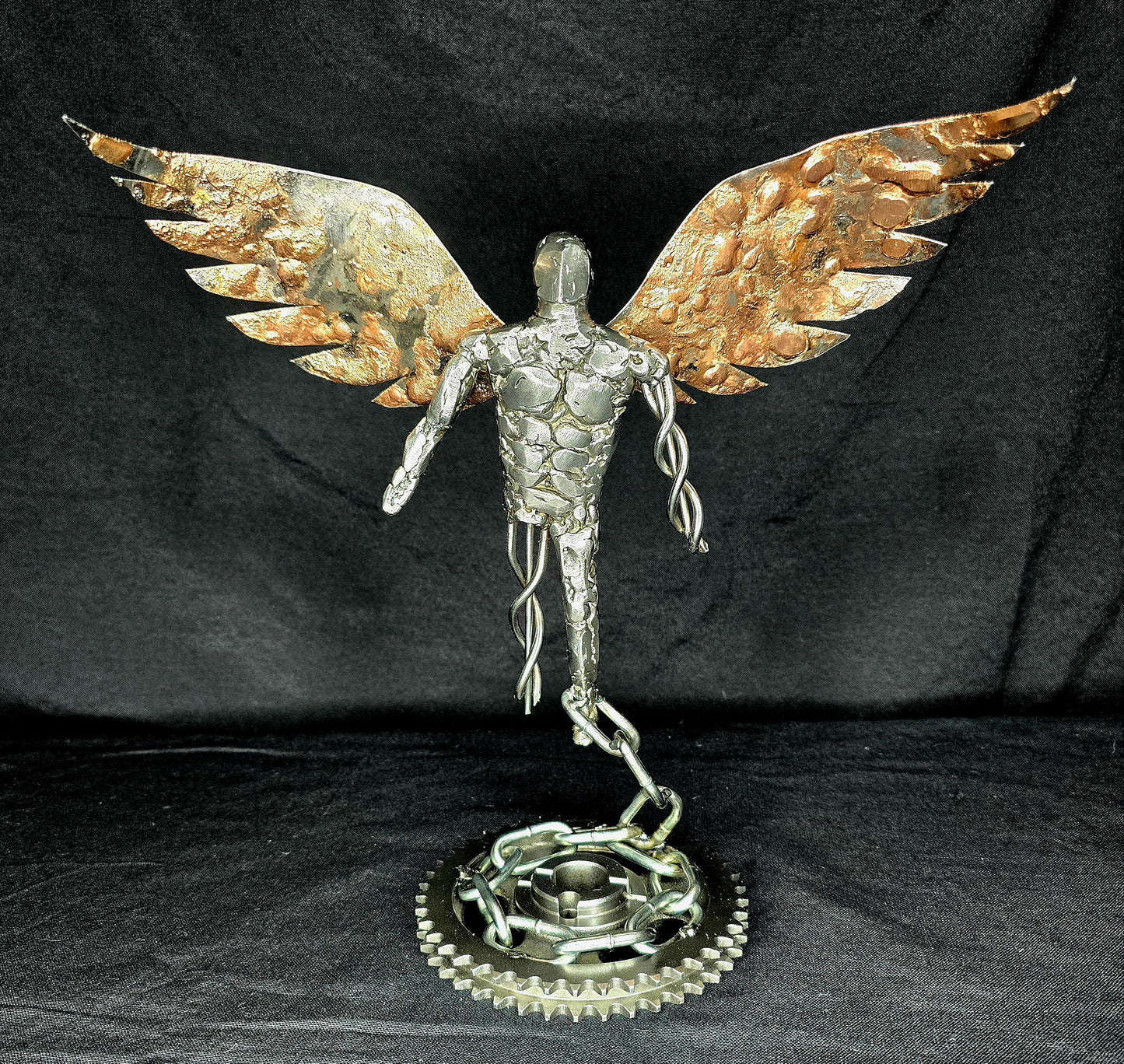 Metal angel ornament front view with gold wings, silver torso, and round gear base