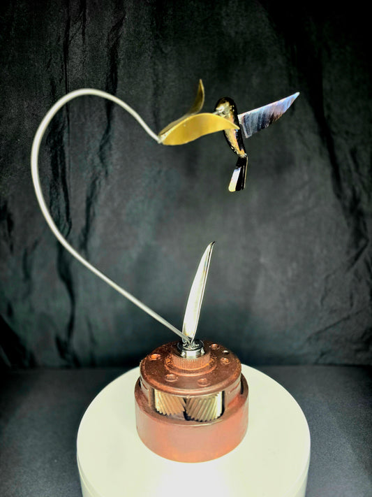 Metal hummingbird figurine with yellow wings on copper base, wired plume details