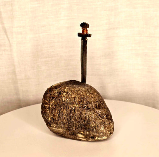 Excalibur sculpture: metal sword with copper wire on a rock.
