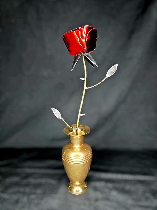 Handcrafted metal rose sculpture with thorns, symbolizing resilience and new life, made from reclaimed steel and brass by Enrique Del Angel.