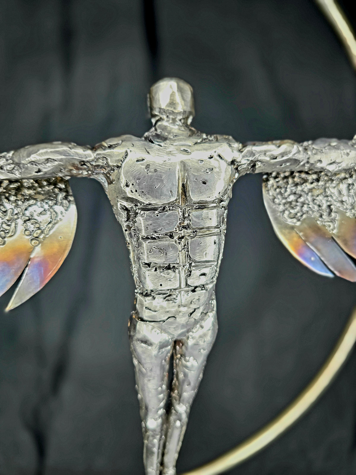 Ikarus: The Day After sculpture by Enrique Del Angel, a metallic human figure with outstretched arms and textured wings.