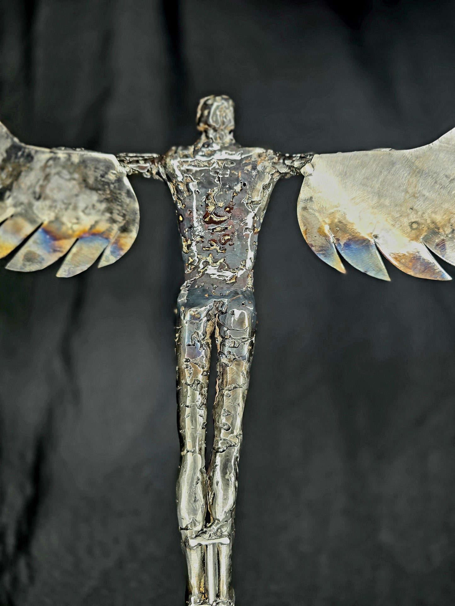 Ikarus: The Day After sculpture by Enrique Del Angel, forged steel figure with heat-colored wings.