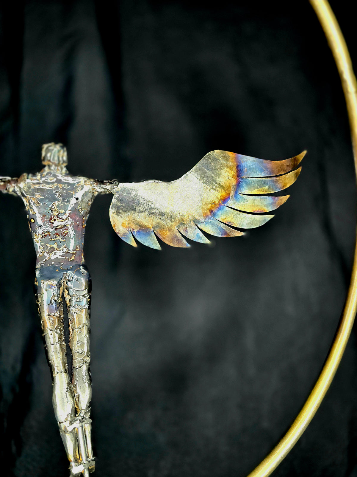 Ikarus: The Day After sculpture by Enrique Del Angel, showing a metal figure with heat-colored wings.