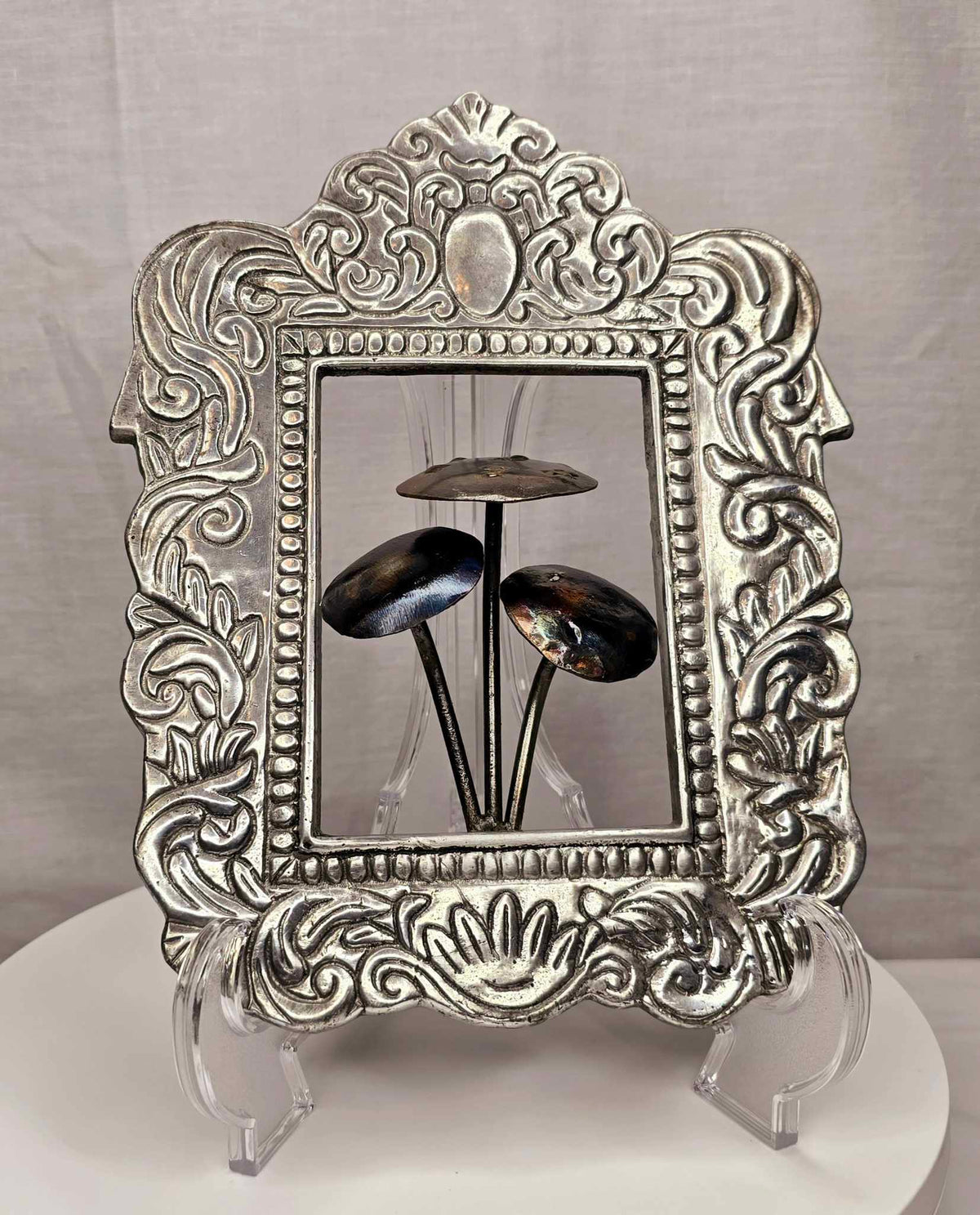 Mushroom of the Forge: Three handcrafted metallic mushrooms inside an ornate silver-tone frame.