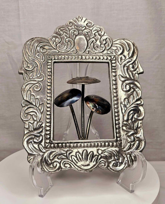 Mushroom of the Forge: Three handcrafted metallic mushrooms inside an ornate silver-tone frame.