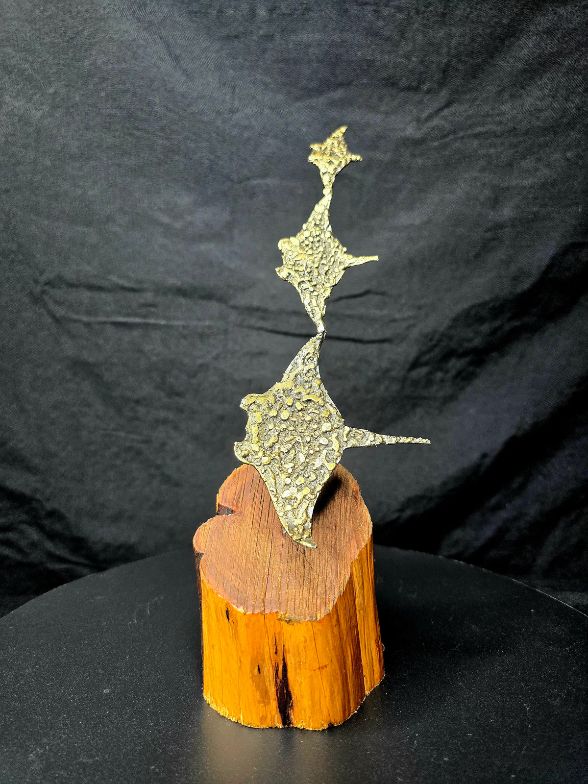 Ray of Sunshine: Three golden hand-formed steel cownose rays on a natural wood base.