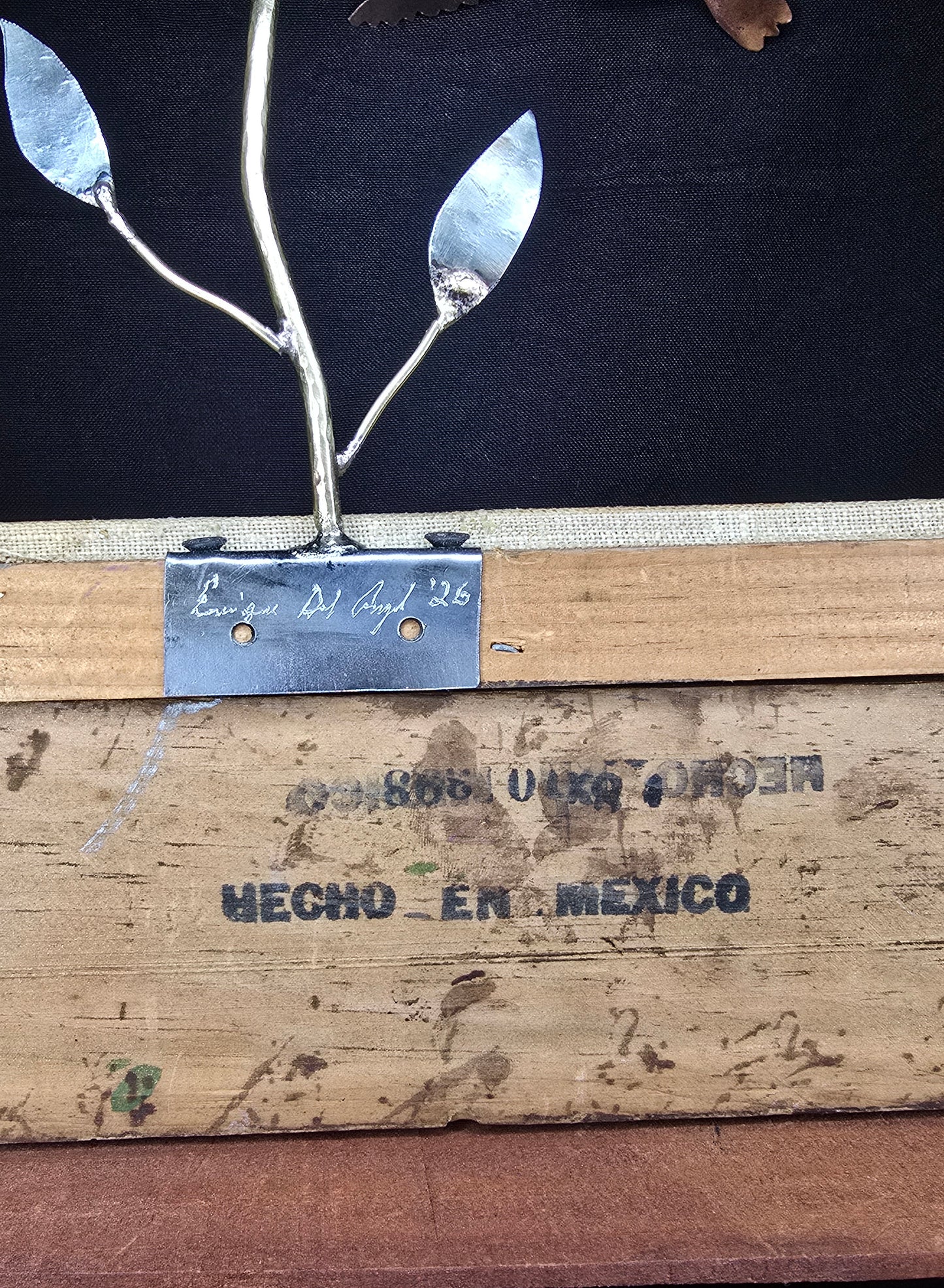 Wooden base of framed metal bird sculpture with engraved 'HECHO EN MEXICO' plaque