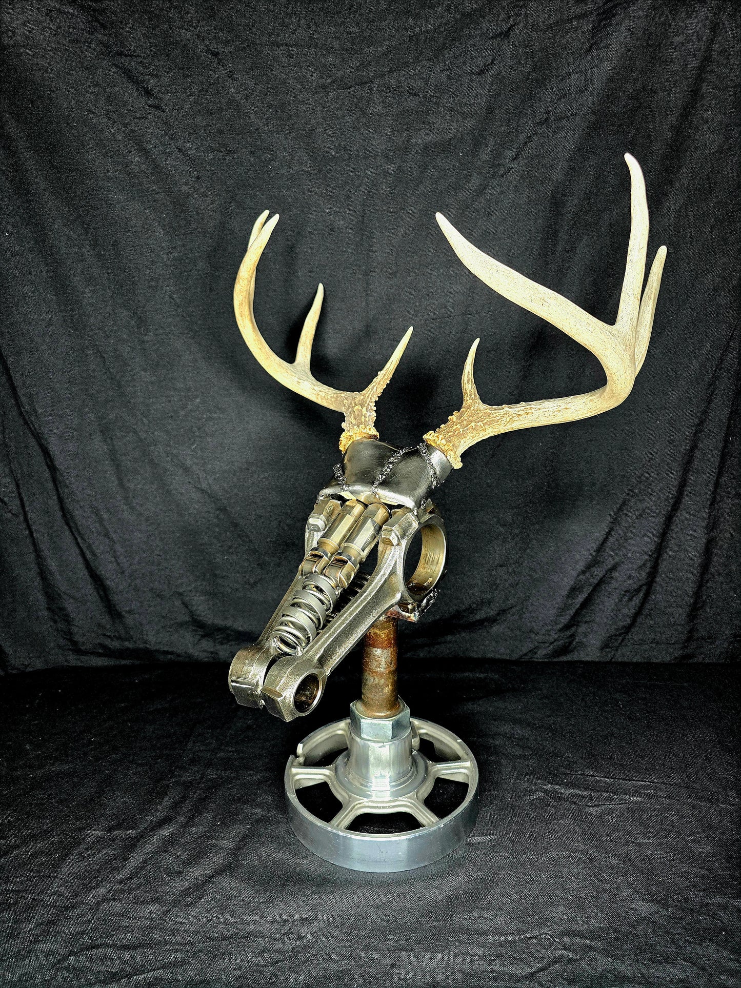 Handcrafted metal deer sculpture with real antlers, made from reclaimed automotive parts by Enrique Del Angel.
