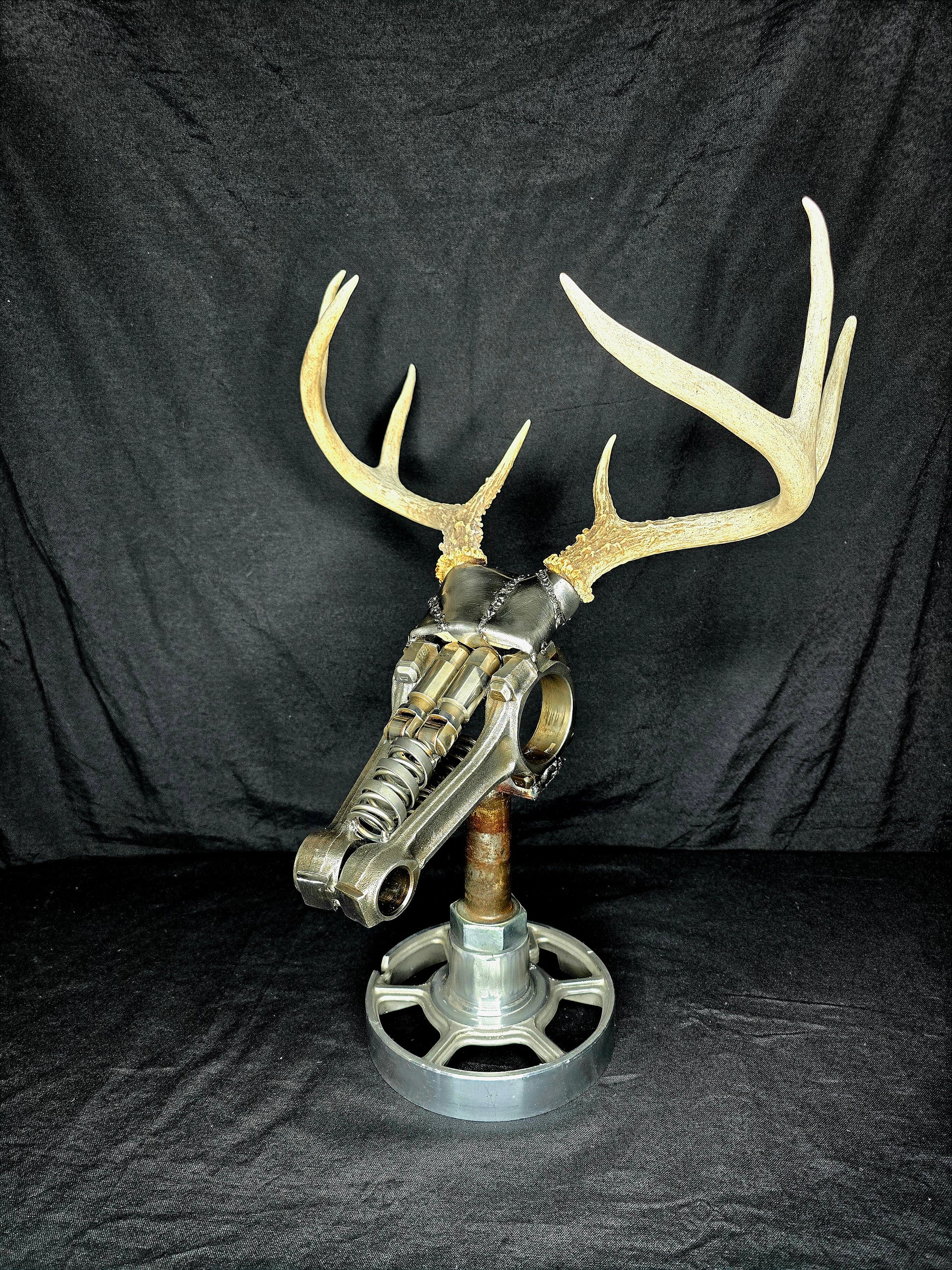 Handcrafted metal deer sculpture with real antlers, made from reclaimed automotive parts by Enrique Del Angel.