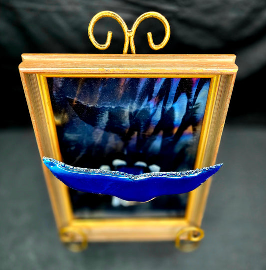 Whale Hello metal sculpture by Enrique Del Angel featuring a blue whale tail displayed in front of a gold-framed artwork.