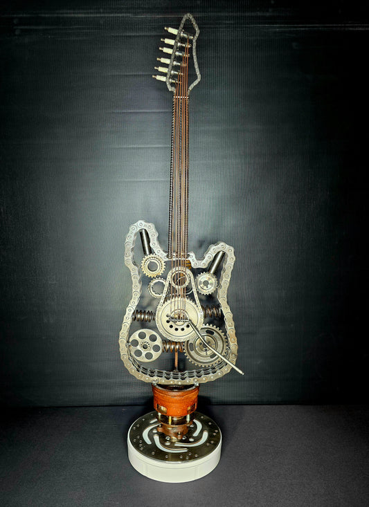 Wired to Rock kinetic metal guitar sculpture by Enrique Del Angel, handcrafted from recycled chains, gears, springs, and engine parts. This interactive 4D sculpture features rotating components that add movement to the industrial guitar design.